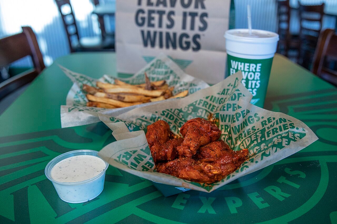 Wingstop classic bone-in chicken wings sauced and tossed with fresh celery sticks and house dip